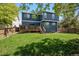 Expansive backyard view features a spacious deck, lush green lawn, and a charming two-story home at 104 Willowick Cir, Highlands Ranch, CO 80129