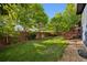 Backyard with a wooden fence, lush green lawn, and mature trees at 104 Willowick Cir, Highlands Ranch, CO 80129