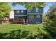 Expansive backyard view features a spacious deck, lush green lawn, and a charming two-story home at 104 Willowick Cir, Highlands Ranch, CO 80129