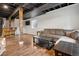 Spacious finished basement with bar, lounge area, exposed ceiling, and hardwood floors at 104 Willowick Cir, Highlands Ranch, CO 80129