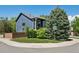 Corner lot showing a charming two-story home with lush landscaping and mature trees at 104 Willowick Cir, Highlands Ranch, CO 80129