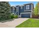 Charming two-story home with blue siding, white trim, well-manicured lawn, and an attached two-car garage at 104 Willowick Cir, Highlands Ranch, CO 80129