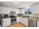 Bright kitchen featuring white cabinets, stainless steel appliances, and light countertops at 104 Willowick Cir, Highlands Ranch, CO 80129