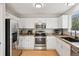Bright kitchen featuring white cabinets, stainless steel appliances, and light countertops at 104 Willowick Cir, Highlands Ranch, CO 80129