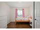 Bright bedroom featuring hardwood floors, a single bed, and cute pink gingham curtains at 986 S Jersey St, Denver, CO 80224