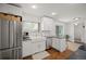 Bright kitchen features stainless steel refrigerator, white cabinets, and a farmhouse sink at 986 S Jersey St, Denver, CO 80224
