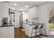 Bright kitchen features white cabinets, stainless steel appliances, and a counter with two stools at 986 S Jersey St, Denver, CO 80224