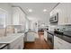 Open kitchen featuring stainless steel appliances, white cabinets, and views into the dining area at 986 S Jersey St, Denver, CO 80224