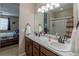 A well-lit bathroom showcasing a dual vanity and a view into the primary bedroom at 915 N Waterloo Ct, Aurora, CO 80018