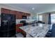 Modern kitchen with dark cabinets, granite countertops, and a large island, perfect for entertaining at 915 N Waterloo Ct, Aurora, CO 80018