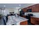 Spacious kitchen featuring a large island with granite countertops, dark cabinetry, and stainless steel appliances at 915 N Waterloo Ct, Aurora, CO 80018