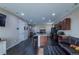 Spacious living area with dark wood floors, recessed lighting, and modern kitchen with a central island and bar seating at 915 N Waterloo Ct, Aurora, CO 80018