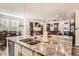Kitchen island with granite countertops and double sink overlooks living room at 9308 Inca Dove Cir, Littleton, CO 80125