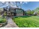 Beautiful backyard view showcasing deck, hot tub, lush lawn, and mature trees, creating a private oasis at 13830 Silverton Dr, Broomfield, CO 80020