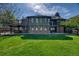 Spacious backyard with lush lawn, mature trees, and a deck, creating a perfect outdoor oasis at 13830 Silverton Dr, Broomfield, CO 80020