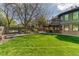 Expansive backyard featuring lush lawn, mature trees, and a deck, perfect for outdoor entertaining at 13830 Silverton Dr, Broomfield, CO 80020