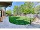 Manicured backyard featuring lush lawn, stone walkway, and mature trees providing shade and privacy at 13830 Silverton Dr, Broomfield, CO 80020
