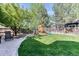 Lush backyard with a playhouse, mature trees, and landscaped pathway creating a Gathering-friendly outdoor space at 13830 Silverton Dr, Broomfield, CO 80020