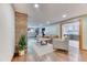 Inviting finished basement with cozy seating area, stone accent wall, and hardwood flooring for relaxed entertaining at 13830 Silverton Dr, Broomfield, CO 80020