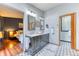 Elegantly remodeled bathroom with dual vanity, patterned tile floors, modern lighting, and neutral gray paint at 13830 Silverton Dr, Broomfield, CO 80020