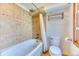Inviting bathroom featuring a jetted tub with tile surround and a convenient towel rack near the toilet at 13830 Silverton Dr, Broomfield, CO 80020