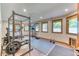 Home gym featuring exercise equipment, including a weight rack and treadmill, with windows for natural light at 13830 Silverton Dr, Broomfield, CO 80020