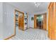 Hallway with white walls, black and white tile floor, and wood trim; access to storage and recreation areas at 13830 Silverton Dr, Broomfield, CO 80020