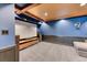 Modern home theater room with blue walls, wood trim and projector, providing an immersive entertainment experience at 13830 Silverton Dr, Broomfield, CO 80020