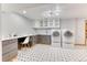 Well-lit laundry room with modern washer and dryer, gray cabinets, and stylish black and white tile flooring at 13830 Silverton Dr, Broomfield, CO 80020