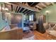 Basement living area with exposed ceiling, gray leather furniture, a desk space, and hardwood floors at 13830 Silverton Dr, Broomfield, CO 80020