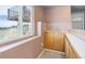 Basement bar area with sink, wood cabinets, and window views to the outside at 10510 Inspiration Dr, Parker, CO 80138
