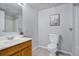 Bathroom with a wood vanity, framed cactus art, white toilet, and white tub and shower at 10510 Inspiration Dr, Parker, CO 80138