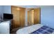 Blue bedroom featuring wood-look flooring, sliding closet doors, and a view into another room at 10510 Inspiration Dr, Parker, CO 80138