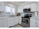 Bright kitchen featuring white cabinets, stainless steel appliances, granite countertops, and stylish backsplash at 10510 Inspiration Dr, Parker, CO 80138