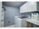 Laundry room with a front load washer and dryer, storage cabinets, and countertops at 10510 Inspiration Dr, Parker, CO 80138