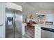 Open-concept living area with hardwood floors, vaulted ceilings, stainless steel refrigerator, and modern lighting at 10510 Inspiration Dr, Parker, CO 80138