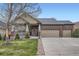 Charming brick and siding home with a three-car garage and a well-manicured lawn at 1978 Granger Cir, Castle Rock, CO 80109