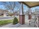 Inviting front porch with brick columns, white railings, and seating overlooking the street at 1978 Granger Cir, Castle Rock, CO 80109