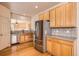 Kitchen with stainless appliances, wood cabinets, and pass-through to living area at 1978 Granger Cir, Castle Rock, CO 80109