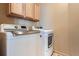 Laundry room featuring modern front load washer and dryer with light wood cabinets at 1978 Granger Cir, Castle Rock, CO 80109