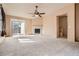 Expansive living room featuring a fireplace, neutral carpeting, and backyard patio access at 1978 Granger Cir, Castle Rock, CO 80109