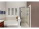 Bathroom showing soaking tub, glass-enclosed shower, and decorative wall art at 7777 E 23Rd Ave # 1406, Denver, CO 80238