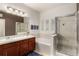 Bathroom with a double sink vanity, soaking tub, and a glass-enclosed shower at 7777 E 23Rd Ave # 1406, Denver, CO 80238