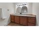 Bathroom with double sinks, wooden cabinets, arched mirrors, and warm lighting for a relaxing atmosphere at 1280 Sable Blvd, Aurora, CO 80011