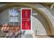 Close up of the front door featuring unique red security door with an arched entrance and house number at 1280 Sable Blvd, Aurora, CO 80011