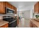 Spacious kitchen features stainless steel appliances and wood cabinets, adjacent to the dining area at 1280 Sable Blvd, Aurora, CO 80011