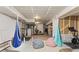 Finished basement with exercise equipment, hanging chairs, and ample space for recreation and fitness at 9391 E 59Th North Pl, Denver, CO 80238