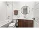 Cozy bathroom featuring a bathtub with shower, sink vanity, and round mirror for comfort and style at 9391 E 59Th North Pl, Denver, CO 80238