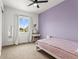 Cozy bedroom with a light purple accent wall, window, vanity, and a plush carpet for comfort and style at 9391 E 59Th North Pl, Denver, CO 80238