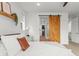 Bright main bedroom showing barn door to main bathroom with closet, refined features, and ample natural light at 9391 E 59Th North Pl, Denver, CO 80238